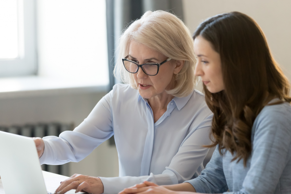 middle aged woman and younger woman looking at a laptop together